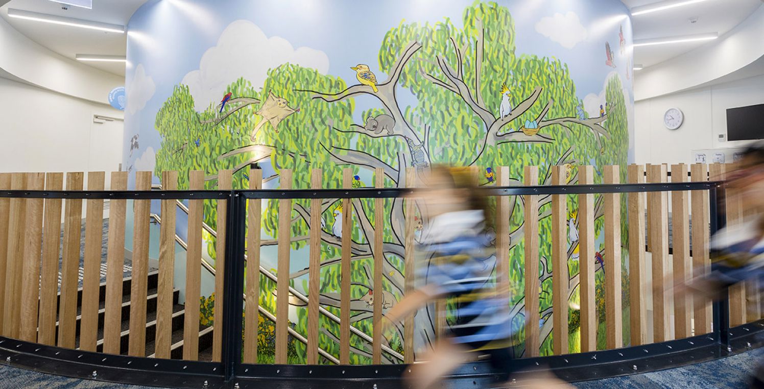Young student running in front of stair banister