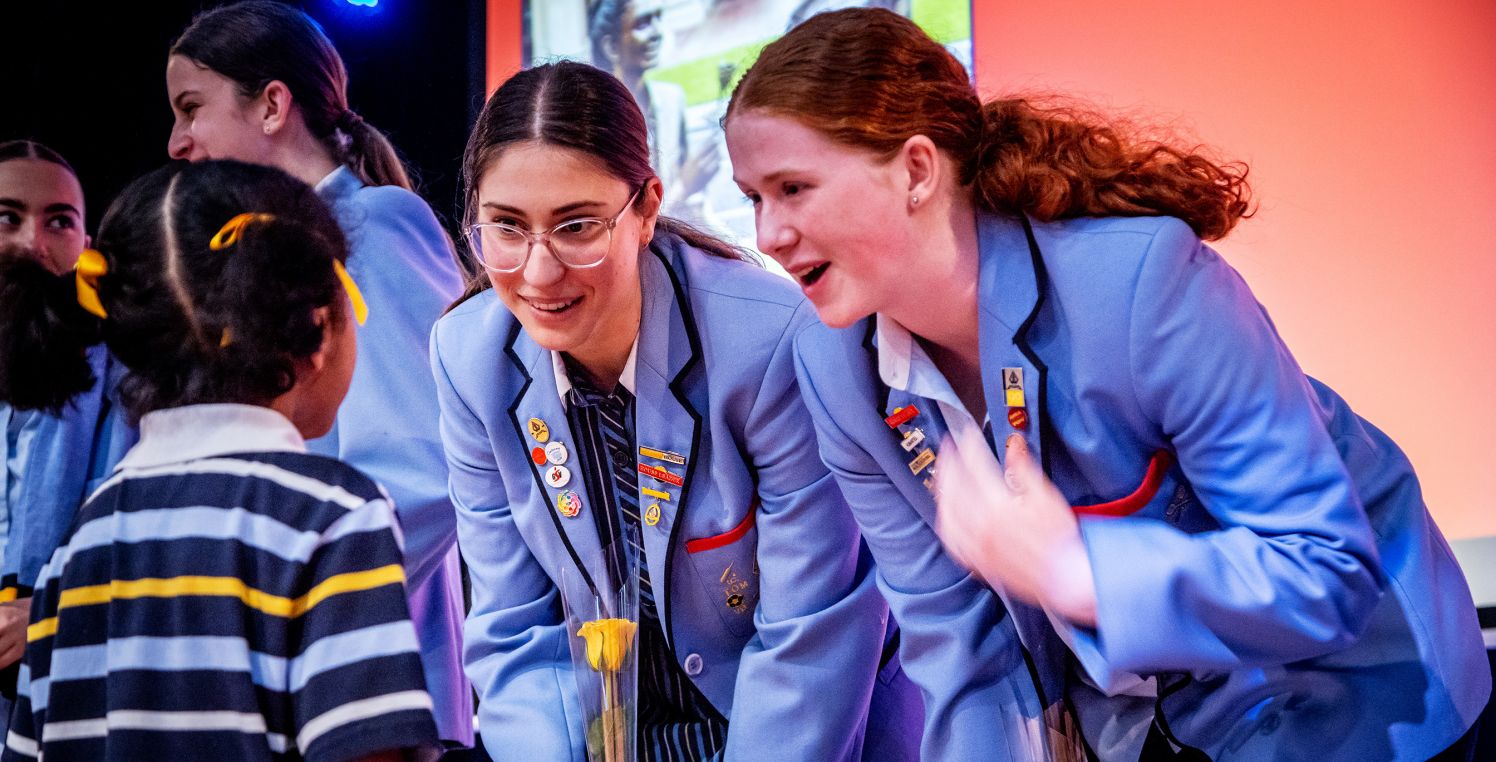 Young student gives roses to Year 12s