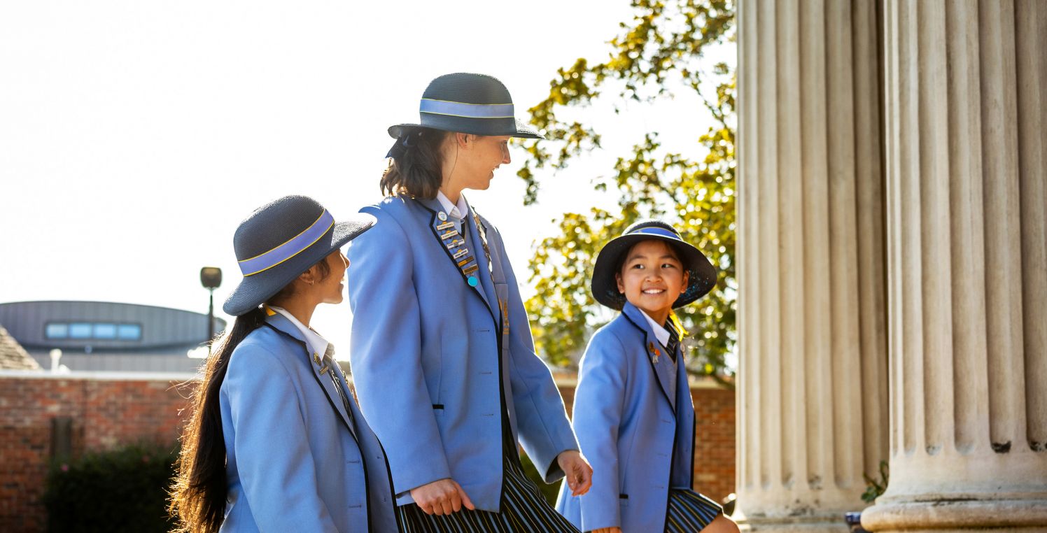 Smiling group of students walking up school steps