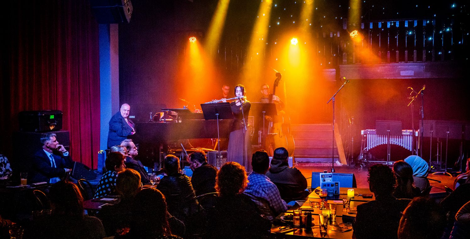 Student playing flute onstage at Jazz event